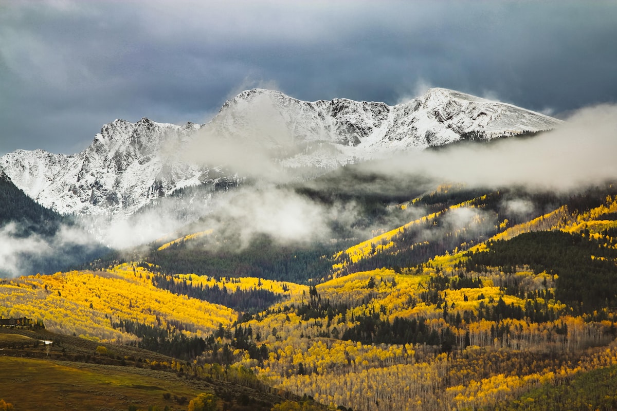 Snow-capped Rocky Mountain peaks above golden aspen forests near Breckenridge, Colorado