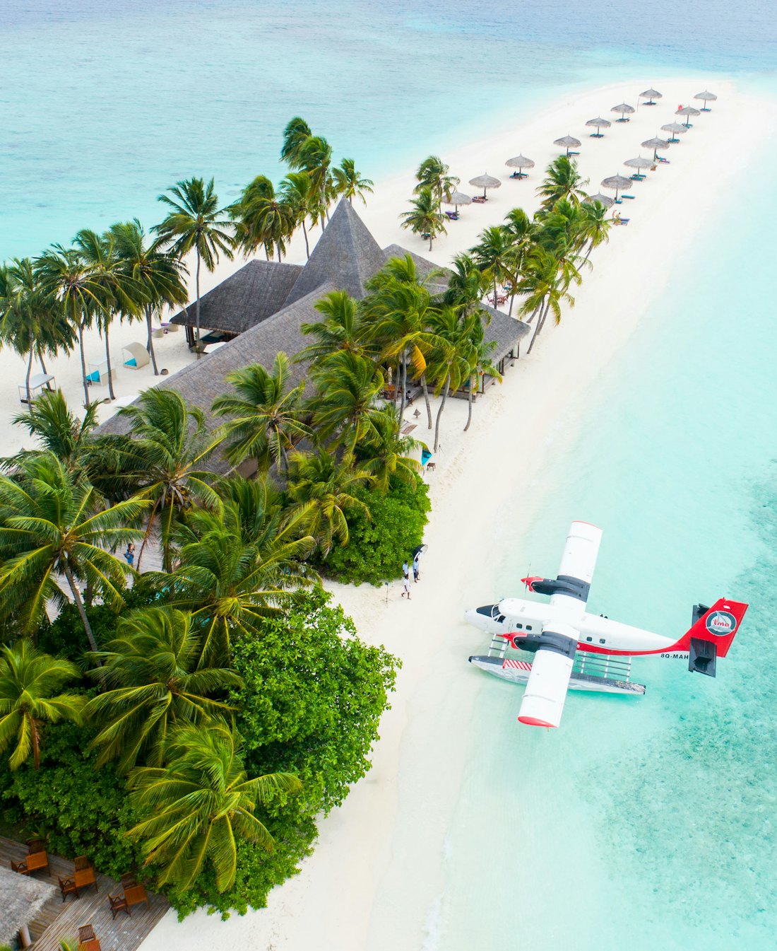 A seaplane arriving at a white-sand island beach